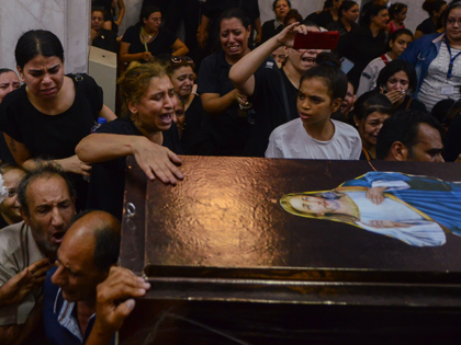 Mourners attend a memorial service for victims of a fire at a church in Greater Cairo that killed dozens on Sunday, Aug. 14, 2022. The blaze ignited at the Abu Sefein church in the densely populated neighborhood of Imbaba while a service was underway, according to the church. (AP Photo/Tarek …