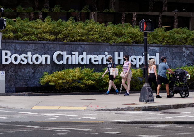 Pedestrians walk past a sign outside the Boston Children's Hospital, Thursday, Aug. 18, 20