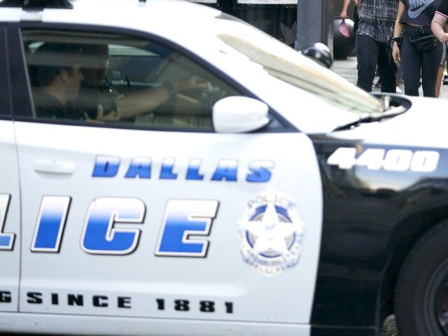 Demonstrators march past a Dallas Police car during a peaceful protest against police brut