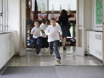 In this Tuesday, June 7, 2016 photo, students run to go outside at the start of a recess between classes at Little Fort Elementary school in Waukegan, Ill. Over the past five years, Waukegan District 60 lost $43 million in state aid because Illinois cut education funding, according to Gwendolyn …