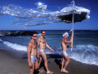 ASBURY PARK, NJ - JULY 20: Contestants in an umbrella decorating contest held during a weekend to promote Asbury Park as a gay destination parade their artwork on the beach, July 20, 2003 in Asbury Park, New Jersey. The Jersey Shore, a 127 mile stretch of coastline known for its …