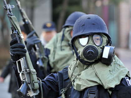 South Korean policemen wearing gas masks stand guard during a civil defence drill at an apartment village in Paju near the Demilitarized Zone (DMZ) separating the two Koreas, on December 15, 2010. South Korea launched its biggest-ever civil defence drill amid high tensions over North Korea's deadly artillery attack last …