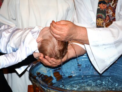 Midsection Of Priest Pouring Water On Baby Boy Head