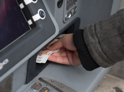 LONDON, ENGLAND - MARCH 10: A member of the public withdraws cash from a cash machine on March 10, 2020 in London, England. It has been reported that a person could also contract the new (Covid-19) coronavirus by touching surfaces or objects that have viral particles on them and then …