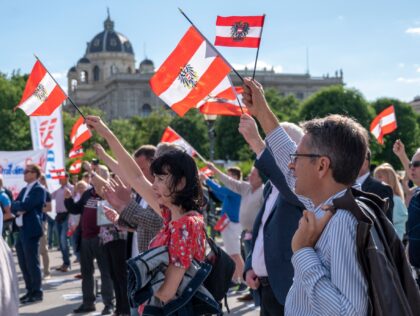 Supporters of the Austrian Freedom Party (FPOe) wave Austrian flags as they attend a protest of the governments measures against the coronavirus pandemic at Helden square in front the Hofburg palace in Vienna, Austria on May 20, 2020. (Photo by JOE KLAMAR / AFP) (Photo by JOE KLAMAR/AFP via Getty …