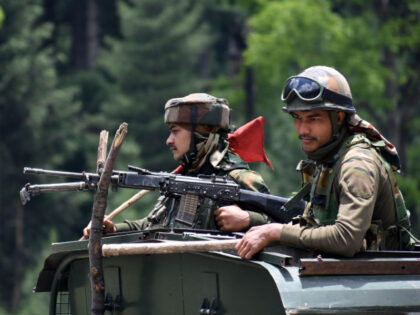 KASHMIR, INDIA-JUNE 17: Indian army soldiers on top of a military vehicle move along the S