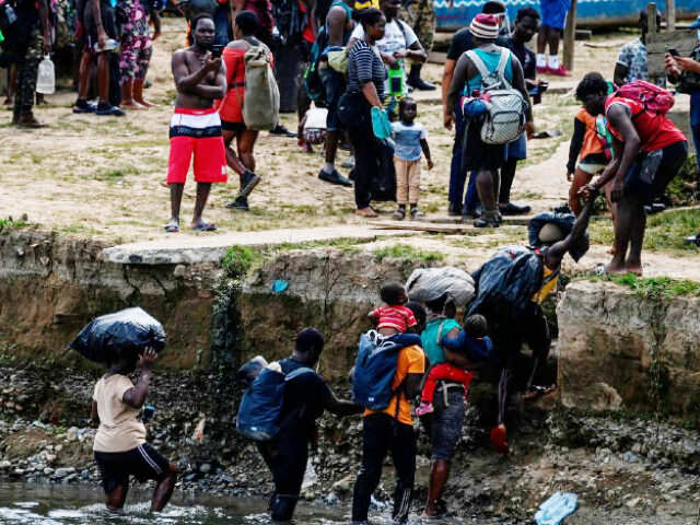 TOPSHOT - Migrants cross the Chucunaque river after walking for five days in the Darien Gap, in Bajo Chiquito village, Darien province, Panama on February 10, 2021, on their way to the US. - Migrants from Haiti and several African countries remain stranded at the Panama-Colombia border, while the Central …