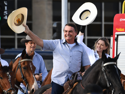 Brazilian President Jair Bolsonaro (C) arrives on horseback at a demonstration by farmers against the Supreme Court and calling for the end of COVID-19 restrictions, in Brasilia, on May 15, 2021 - The rally's organizers have called for conservative "soldiers" to protest the "craziness" of pandemic stay-at-home measures and Brazil's …