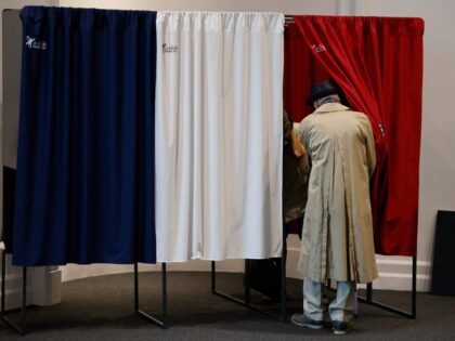 TOPSHOT - Voters enter a polling booth equipped with anti-covid curtains at a polling station in Le Touquet, for the second round of the French regional elections on June 27, 2021. (Photo by Ludovic MARIN / POOL / AFP) (Photo by LUDOVIC MARIN/POOL/AFP via Getty Images)