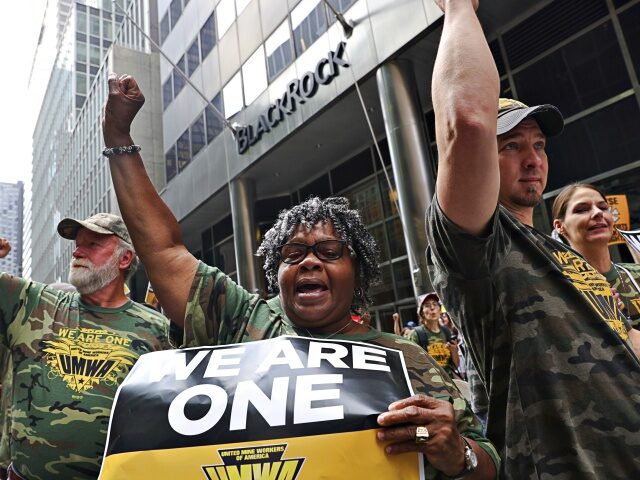 Members of the United Mine Workers of America (UMWA) raise their fists during a strike aga