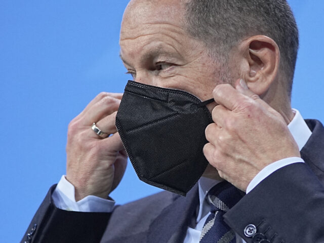 Newly elected German Chancellor Olaf Scholz puts on his face mask after a press conference