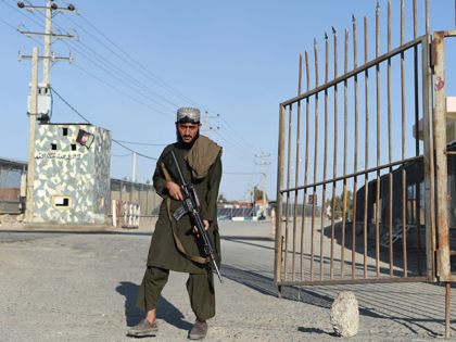 In this photo taken on February 18, 2022 a Taliban fighter stands guard at the entrance gate of Afghan-Iran border crossing bridge in Zaranj. (Photo by Wakil KOHSAR / AFP) (Photo by WAKIL KOHSAR/AFP via Getty Images)