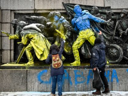 TOPSHOT - People paint the figures of Soviet soldiers using Ukranian flag colours at the base of the Soviet Army monument in Sofia, on February 27, 2022 in reaction to Russia's invasion of Ukraine. - Ukrainian forces said they had fought off a Russian incursion in Ukraine's second-biggest city on …