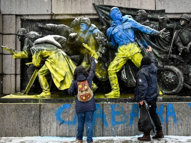 TOPSHOT - People paint the figures of Soviet soldiers using Ukranian flag colours at the b