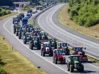 TOPSHOT - Tractors drive down the A1 highway between Apeldoorn and Stroe on their way back from a rural farmers' protest against the government's plan to curb nitrogen pollution by 70 percent by 2030, in Stroe, 70 kilometres east of Amsterdam on June 22, 2022. - Thousands of farmers on …