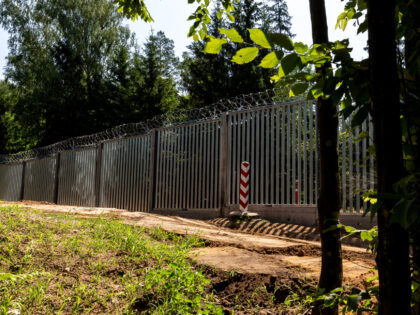 Polish border pole is seen against the physical barrier between Poland and Belarus in the