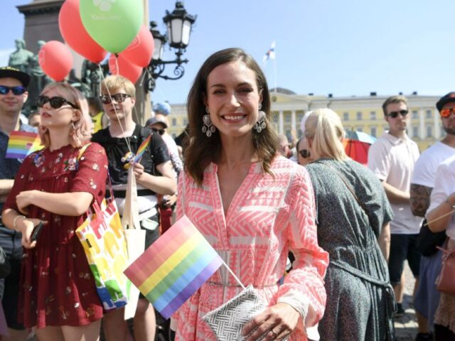 Finnish Prime Minister Sanna Marin holds a rainbow flag as she takes part in the 2022 Hels