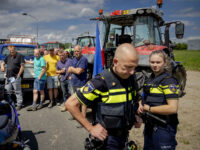 Police officers leave after speaking with farmers holding a blockade at a distribution center of supermarket chain Lidl in Almere, on July 5, 2022, to protest against government plans that may require them to use less fertilizer and reduce livestock - Netherlands OUT (Photo by Robin van Lonkhuijsen / ANP …