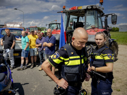 Police officers leave after speaking with farmers holding a blockade at a distribution cen