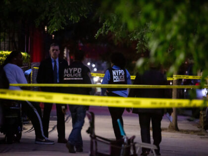 New York Police Department (NYPD) officers investigate the scene of a shooting in the Crow