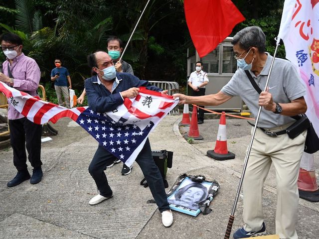 Pro-Beijing protesters rip up a US flag after stamping on an image depicting the US House Speaker Nancy Pelosi at a protest outside the US Consulate in Hong Kong on August 3, 2022 after Pelosi arrived in Taiwan late on August 2, 2022 as part of a tour of Asia that has inflamed tensions between the US and China. (Photo by Peter PARKS / AFP) (Photo by PETER PARKS/AFP via Getty Images)