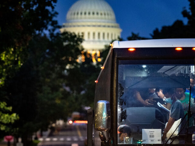 WASHINGTON, DC - AUGUST 11: Migrants disembark a bus from Texas within view of the U.S. Ca