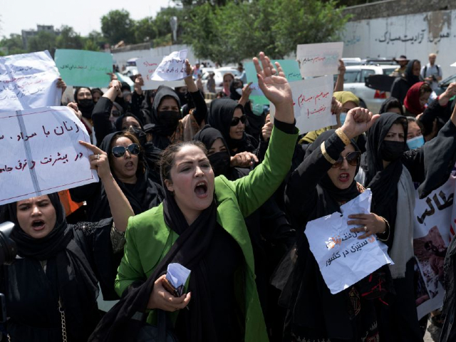 Afghan women hold placards as they march and shout slogans "Bread, work, freedom" during a womens' rights protest in Kabul on August 13, 2022. - Taliban fighters beat women protesters and fired into the air on Saturday as they violently dispersed a rare rally in the Afghan capital, days ahead of the first anniversary of the hardline Islamists' return to power. (Photo by Wakil KOHSAR / AFP) (Photo by WAKIL KOHSAR/AFP via Getty Images)