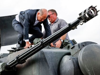 German Chancellor Olaf Scholz (L) climbs with head of training at arms manufacturer Krauss