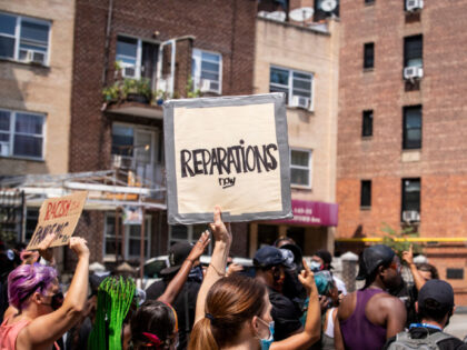 BAYSIDE, NY - AUGUST 01: A large crowd of protesters wearing masks and carrying signs that say, "Reparations Now" as they walk through neighborhoods at the Black Lives Matter protest in Bayside, Queens. This peaceful protest was a March against Police violence against people of color and a reaction to …