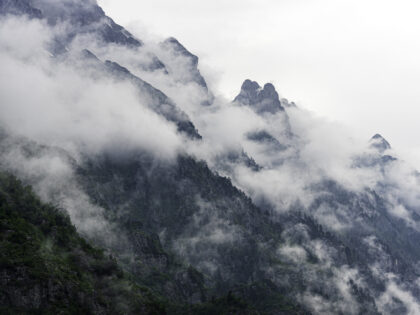 an atmospheric photo of mountain peaks peaking out of low lying clouds.