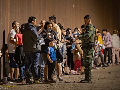 YUMA, ARIZONA - JUNE 22: A U.S. Border Patrol agent checks for identification of immigrants as they wait to be processed by the U.S. Border Patrol after crossing the border from Mexico on June 22, 2022 in Yuma, Arizona. (Photo by Qian Weizhong/VCG via Getty Images)