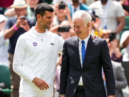 Novak Djokovic (L) of Serbia greet with John McEnroe during the Centre Court Centenary Celebration during day seven of The Championships Wimbledon 2022 at All England Lawn Tennis and Croquet Club on July 03, 2022 in London, England. (Photo by Shi Tang/Getty Images)