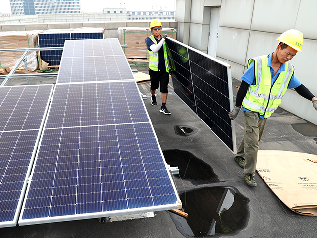 Workers install solar panels on the roof of factory buildings at a small and medium-sized enterprises park on July 5, 2022 in Lianyungang, Jiangsu Province of China. (Photo by VCG/VCG via Getty Images)