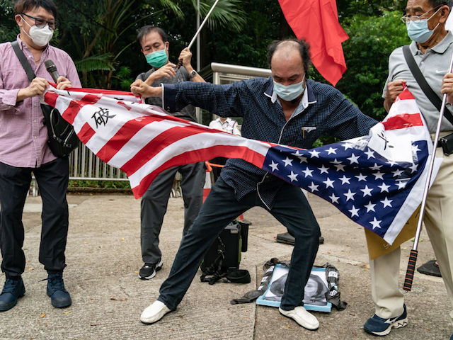 HONG KONG, CHINA - AUGUST 03: Pro-China supporters tear a U.S. flag during a protest against U.S. House of Representatives Speaker Nancy Pelosi's visit to Taiwan outside the Consulate General of the United States on August 03, 2022 in Hong Kong, China. Pelosi arrived in Taiwan on Tuesday as part of a tour of Asia aimed at reassuring allies in the region, as China made it clear that her visit to Taiwan would be seen in a negative light. (Photo by Anthony Kwan/Getty Images)