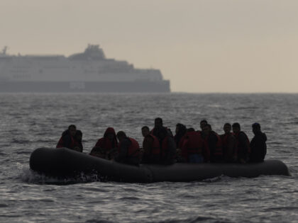 AT SEA, ENGLAND - AUGUST 04: An inflatable craft carrying migrants crosses the shipping la