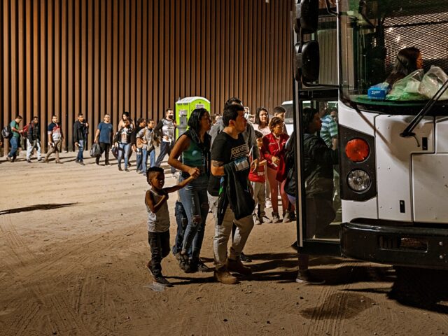 YUMA, ARIZONA - AUGUST 06: A U.S. Border Patrol agent monitors immigrants as they enter a Border Patrol vehicle to be taken for processing, after crossing the border from Mexico on August 6, 2022 in Yuma, Arizona. (Photo by Qian Weizhong/VCG via Getty Images)