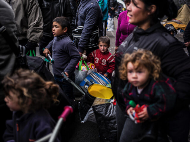 Albanian asylum seekers wait with their luggage early on November 18, 2013 in Lyon, southe