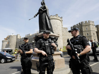 Aremed British police officers patrol near Windsor Castle in Windsor on May 18, 2018, the day before the Royal wedding. - Britain's Prince Harry and US actress Meghan Markle will marry on May 19 at St George's Chapel in Windsor Castle. (Photo by Tolga AKMEN / AFP) (Photo credit should …