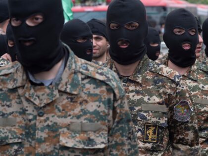 Islamic Revolutionary Guard Corps (IRGC) military personnel stand guard on an avenue in do