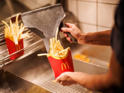An employee fills a bag with French fries at a branch of the McDonald's fast food chain on Martin-Luther-Strasse in Giesing. The branch opened its doors on 4 December 1971 as the first McDonald's branch in Germany. Photo: Matthias Balk/dpa (Photo by Matthias Balk/picture alliance via Getty Images)