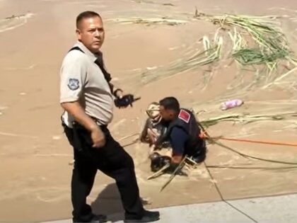 A Mexican firefighter pulls the lifeless body of a five-year-old Guatemalan girl from the Rio Grande near Juarez. (Canal44 Video Screenshot)