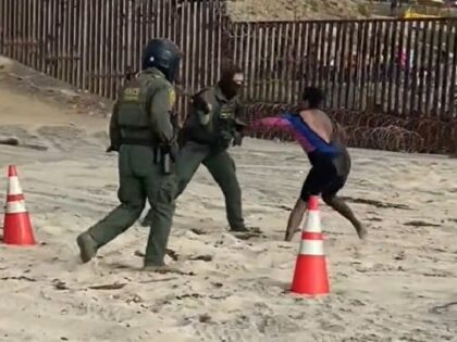 Two Border Patrol agents from San Diego work to arrest an assaultive migrant. (U.S. Rep. Mayra Flores video screenshot)