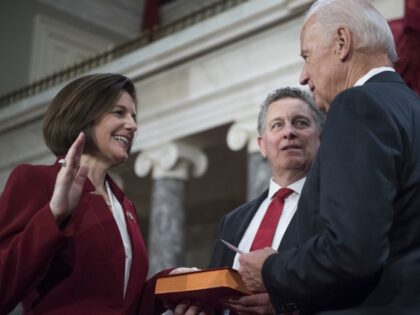 Sen. Catherine Cortez Masto, D-Nev., is administered an oath as her husband Paul looks on,