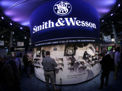 FILE - In this Tuesday, Jan. 14, 2014 file photo, trade show attendees examine handguns and rifles at the Smith & Wesson display booth at the Shooting Hunting and Outdoor Trade Show, in Las Vegas. Smith & Wesson announced Thursday, Sept. 30, 2021, it plans to move its headquarters from …