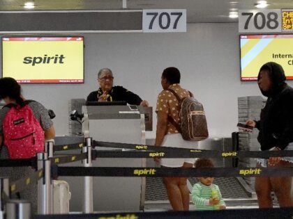 Passengers wait at the Spirit airlines counter in the Miami International Airport on July