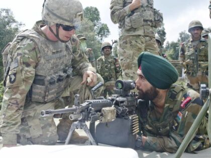 A U.S. Soldier with 5-20th Infantry Regiment, 1-2 Stryker Brigade Combat Team, teaches an Indian soldier with 12 Madras how to fire an M249 Squad Automatic Weapon Sept. 18, 2016, at Chaubattia Military Station, India. This was part of Yudh Abhyas 2016, a bilateral training exercise geared toward enhancing cooperation …