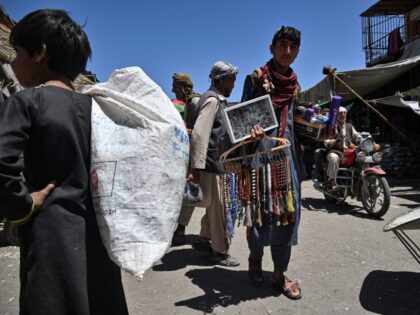 A youth selling prayer beads and jewelry looks for customers at a market in Kabul on August 9, 2022. (Photo by Lillian SUWANRUMPHA / AFP) (Photo by LILLIAN SUWANRUMPHA/AFP via Getty Images)