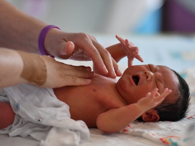 FUYANG, CHINA - AUGUST 08 2022: A nurse massages a newborn baby in a maternity hospital in Fuyang in central China's Anhui province Monday, Aug. 08, 2022. As the birth rates keeps dropping in China, the country is expected to encounter negative population growth soon. (Photo credit should read AN …