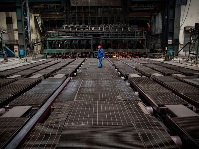 CHANGZHOU, CHINA - MAY 12: A worker supervises the production of steel bar on the line at