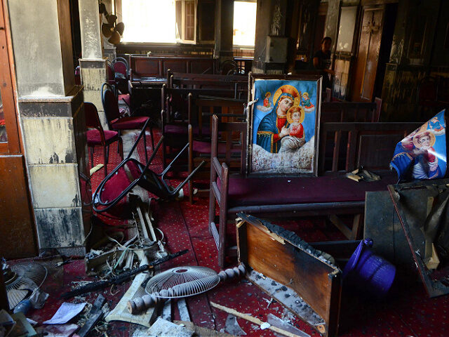 Burned furniture, including wooden tables and chairs, and a religious images are seen at t